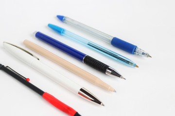 Pens of different colors and sizes on a white background
