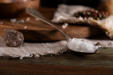 Coarse salt in an old spoon on a wooden table