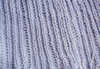 Background or texture of blue hand-knitted plaid and pillows in cosy autumn or winter home.