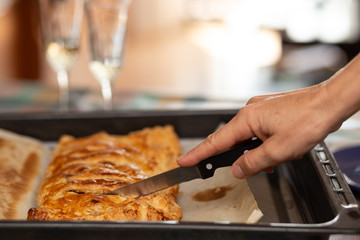 woman hand cutting a slice of apple strudel