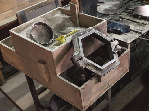 From above of hexagonal metal constructions for making panels for tiles on wooden container in workshop