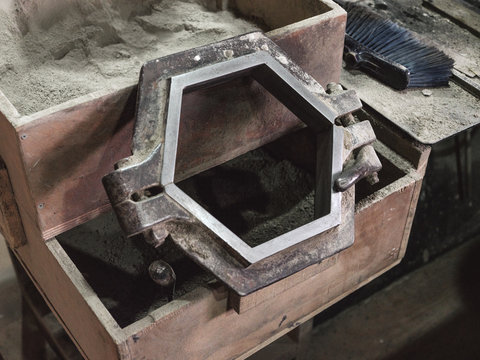 From above of hexagonal metal constructions for making panels for tiles on wooden container in workshop
