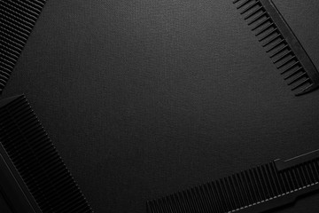 On a black surface are old hairdresser tools. combs. black monochrome. horizontal orientation. top view. frame