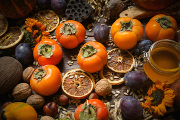 Pumpkins, persimmon, cereals, bread, seeds and nuts on a wooden background, Harvest, Autumn