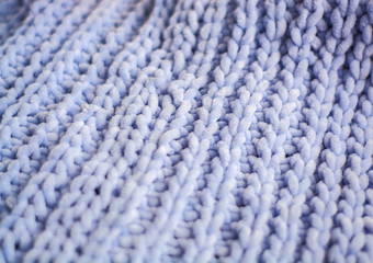 Background or texture of blue hand-knitted plaid and pillows in cosy autumn or winter home.