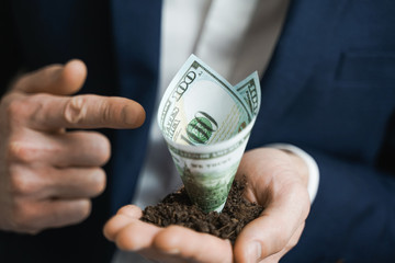 100 dollars growing money in businessman hands. Investment And Interest Concept. businessman protects growing investments.