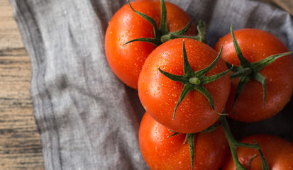 From above of wet clean tomatoes placed on gray fabric napkin on grey concrete table background