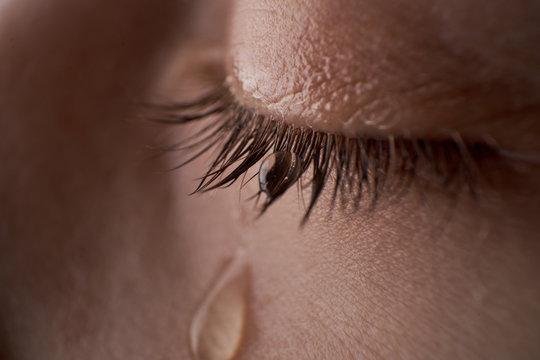 Close up image of human eye with tear drops