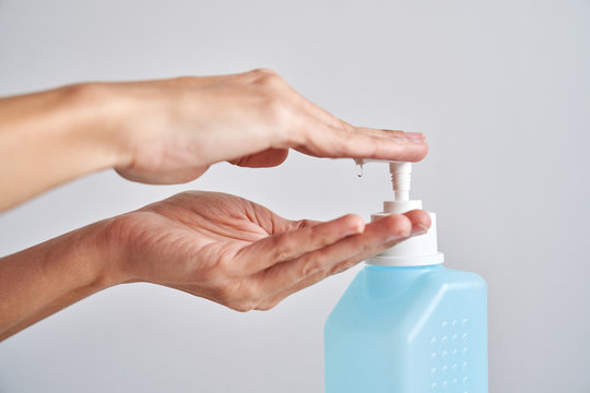 Woman cleaning her hands with alcohol antiseptic gel to prevent infection