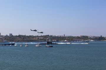 Fototapeta na wymiar Mi-28 attack helicopters fly by at the parade in honor of Navy Day in Sevastopol Bay, Crimea