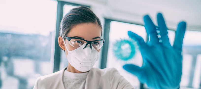 COVID-19 Researcher Looking At Virus Model In Search Of A Cure. Coronavirus Lab Research Woman Vaccine Holding Corona Virus Blue Sphere Of COVID-19. Panoramic Banner.