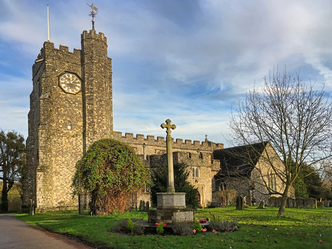 The 13th century Church of St Mary's is noted for its stained glass window and fine monuments. Memorial cross in the grounds of Church, Chilham, Kent, UK
