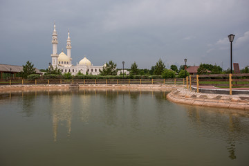 A beautiful white mosque in the city of Bulgarians is reflected in the water against the backdrop...