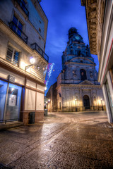 Naklejka premium rue de nuit vide avec bâtiment du XIXe siècle et église de nuit avec des décors de noël à Nantes en France