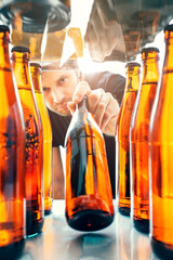 Caucasian man takes cold refreshing beer from the fridge on a hot sunny sultry day - quench his...