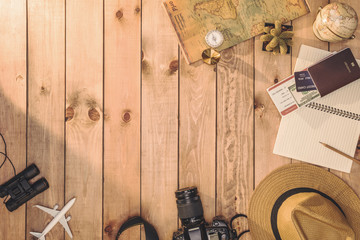 Overhead view of Traveler's accessories Essential vacation items, and Different objects on wooden background. Travel concept background