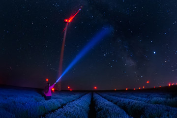 Beautiful landscape of a starry night with milky way and blue sky over a field of lavender and red...
