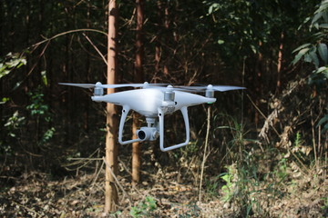 Drone flying with trees in the background