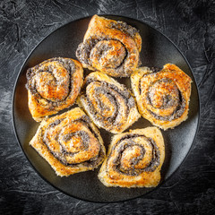 homemade rolls with poppy seeds on the dark background
