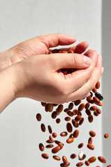 Beans are strewed through the hands of a woman.