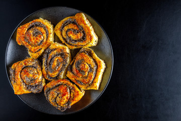 homemade rolls with poppy seeds on the dark background