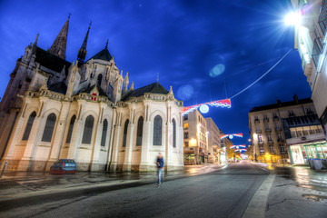 Fototapeta na wymiar rue de nuit vide avec bâtiment du XIXe siècle et église gothique de nuit avec des décors de noël à Nantes en France