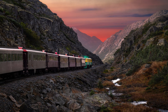 Old Historic Railroad Train is going over White Pass. Moody Colorful Sky Composite. Skagway, Alaska, United States