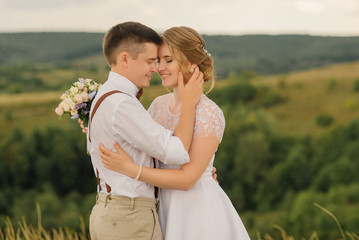 Happy bride and groom enjoy each other against the backdrop of beautiful landscapes of nature. Wedding day.