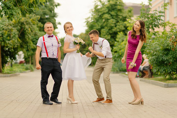 Obraz premium The bride and groom have fun with their friends on their wedding day.