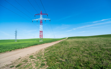 Electric pole in the center of the beautiful green fields