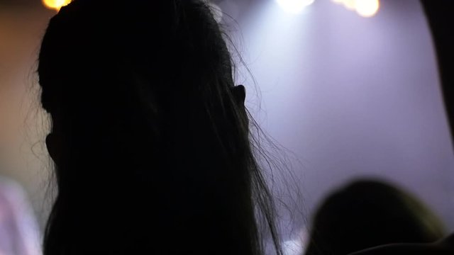 Woman dancing and jumping in front row at a concert