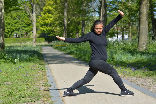 Asian Woman Doing Tai Chi In A Park