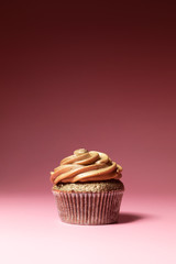 Luxury chocolate cupcake from low perspective isolated against pink background.