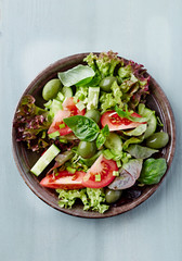 Healthy salad with green olives, cucumber and tomatoes. Top view.