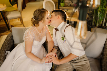 The bride and groom kiss while in the Loft interior before the wedding ceremony.