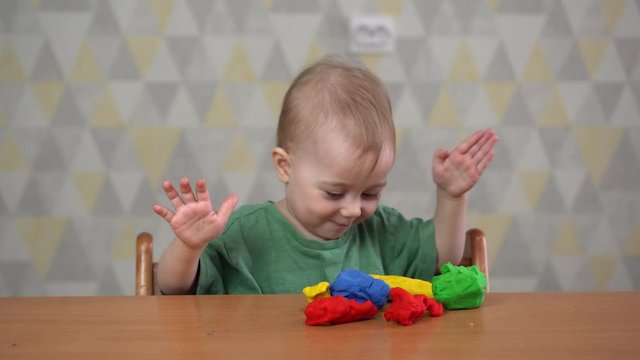 a little one-year-old girl playing with plasticine