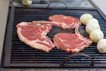 Some pieces of sirloin steak and some green onions on a grill 