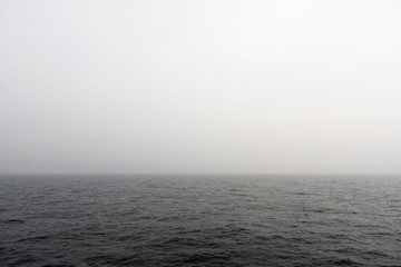 Seascape. Fog in the sea. The ship follows in the fog. View from the navigation bridge. Navigator's watch service on a cargo ship.