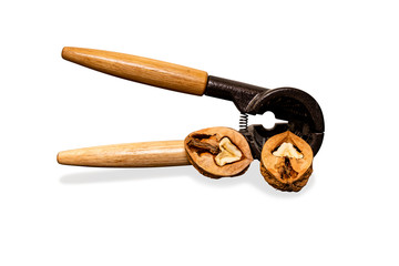 Eine geöffnete Walnuss und ein Nussknacker auf weißem Hintergrund.