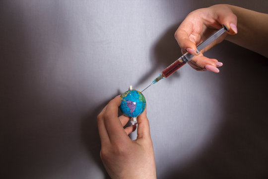 doctor holds globe and syringe