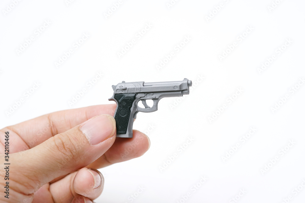 Wall mural hand holding tiny model automatic gun on white background