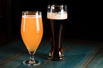 Poured beer on a dark background on a wooden table. The concept of relaxation and pastime