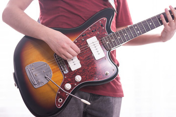 Playing a Fender Jazzmaster electric guitar