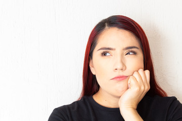 Hispanic redhead woman pensive and doubting on a white background