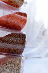 jars of cereal lentil buckwheat oatmeal lined on top of each other against the background of the window view from the side