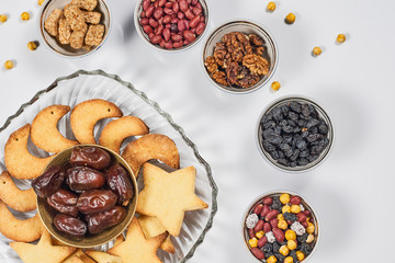 Iftar foods on white table. Traditional middle-eastern lunch with cookies and dry date fruits