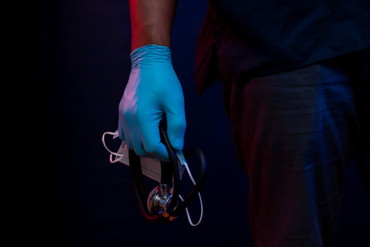 Close up of conceptual African American health care professional hand with stethoscope and gloves