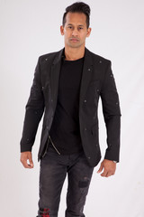 Fototapeta premium Handsome man in black shirt and jacket looking thoughtful