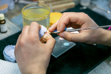 Denture layout. Technician enamels a tooth. Dental laboratory, implantation. Close-up