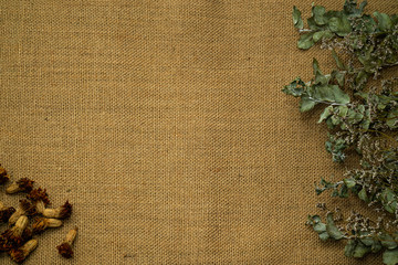 Dried roses and dry rose leaves lie on burlap background